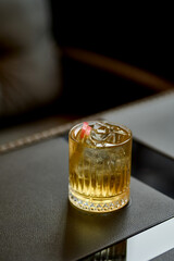 Alcoholic cocktail with ice and apple on brown satin background