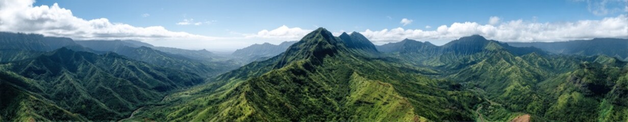 Obraz premium Scenic panorama of lush green mountain range under clear blue sky.