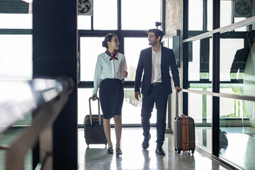 Flight attendant is walking together with pilot captain at the airport while on the way to boarding aircraft