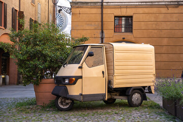 typical van-type motorcycle tricycle, parked in the historic center of an Italian city