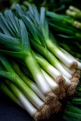 Obraz premium Fresh leeks showing white stalks and green leaves at farmers market