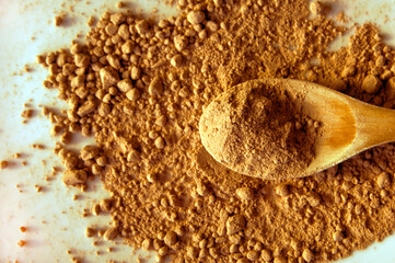 Cocoa Powder and Wooden Spoon on White Background – Top View with Texture