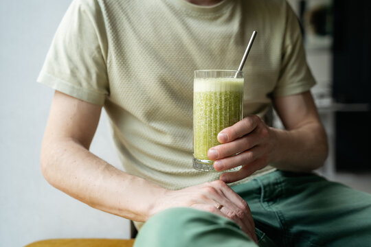 Man Drinking Healthy Green Smoothie. concepts related to wellness, nutrition, detox, and eco-conscious living