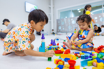 Kindergarten kids boy and girl enjoy toy block building