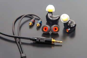 Premium in-ear headphones with modular design, including black earbuds, colorful ear tips, and a...