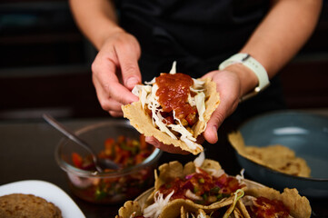 Hand Preparing Taco with Fresh Ingredients Highlighting Mexican Cuisine and Healthy Food Choices