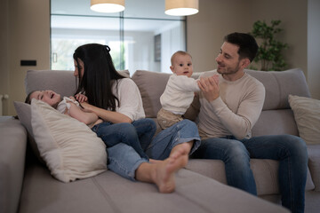 Happy family playing and relaxing on sofa at home