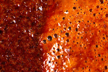 Macro close-up of frothy coffee crema with golden-brown bubbles, showcasing rich texture and reflective surfaces. Perfect for coffee lovers, beverage ads, or food photography