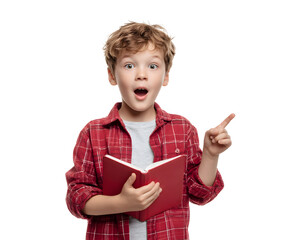 A boy with an open book looks surprised and points to something interesting he's reading about.