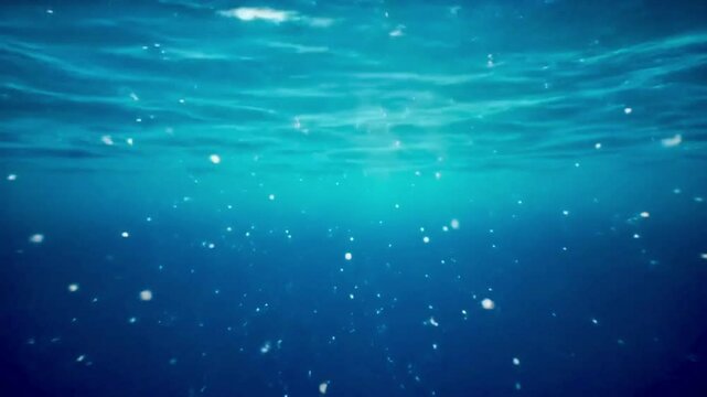 Light beams piercing through clear blue ocean water from above, particles floating, peaceful underwater loop