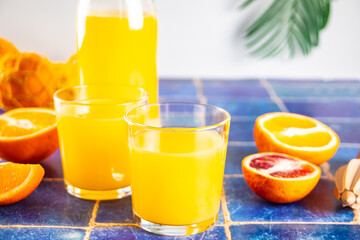 Fresh orange juice on table with slices fruits.