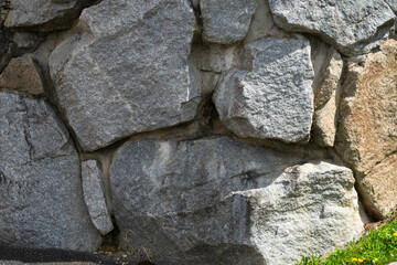 Stacked stone brick wall. Stone cladding wall made of striped stacked slabs of natural grey rocks. Panels for exterior. pattern of decorative slate stone wall surface. Stone cladding wallpaper.