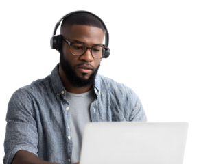 An african american man, focused on his laptop, wearing glasses and headphones.
