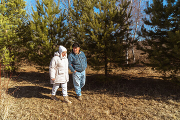 Fototapeta premium Romantic and elderly healthy lifestyle concept. Senior active Caucasian couple holding hands looks happy in park in autumn forest,happy anniversary,happily retired married couple together