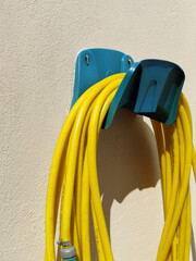 Hose water. Garden hose coiled on a support. Yellow hose for watering plants