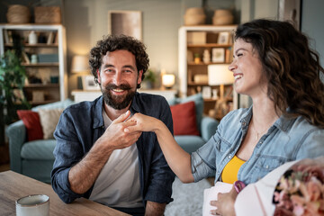 Happy couple holding hands and smiling at home