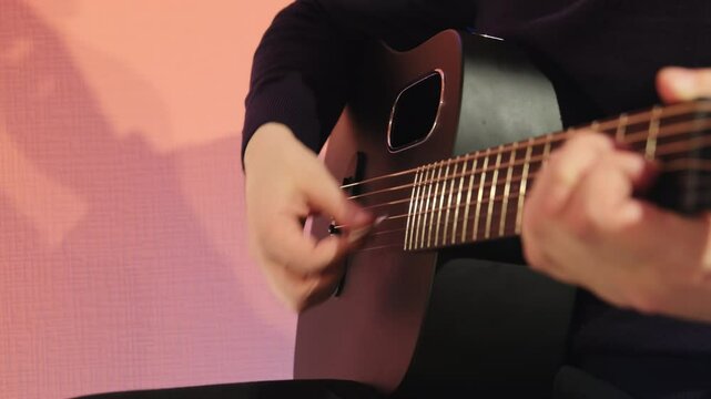 Musician speaks emotions through playing guitar in studio. Music becomes reflection of man innermost thoughts and feelings slow motion