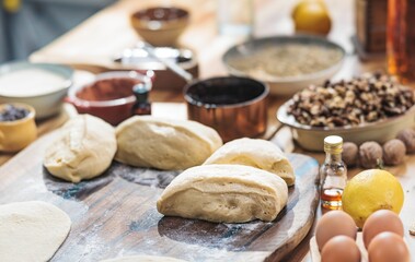 Fingers coated in flour expertly knead, shape, and rest silky yeast dough on a wooden surface, highlighting the craftsmanship involved in traditional baking