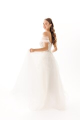 Fototapeta premium Elegant bridal portrait showcasing a bride in a flowing white gown against a light background