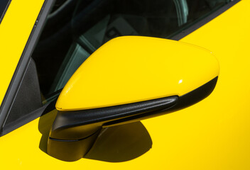 Close-up sport car side mirror yellow color with LED turn signal, modern sport car safety systems. Close up of a yellow sports car's front fender. Yellow rear view mirror new car.