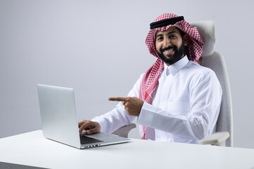 A collection of images of Arab business professionals, both male and female, in traditional clothing working together in a modern office setting, using laptops, discussing projects, and collaborating 