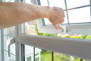 Homeowner seen pulling shut a newly installed double glazed window with leaded flashing. Part of...