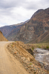 Gravel road running along Chulyshman river in mountain valley Altai Russia Remote travel route through scenic wilderness