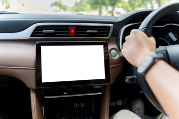 Naklejka premium Driver hand on steering wheel with blank touchscreen in modern car interior and start button dashboard