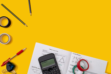 A frame of school accessories on a yellow background. Pen, protractor, tape, pencil sharpener,...