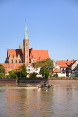Wroclaw, Poland, September 21, 2024 &mdash; Emergency services patrol the flooded Oder River by motorboat near the Cathedral of St. John the Baptist, amid rising water levels threatening city infrastructure