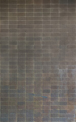 Fototapeta premium Textured wall with colorful tiles showcasing unique patterns and shades of light and darkness