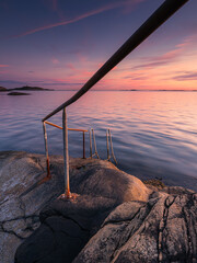 Sunset casts warm colors on stairway leading to the sea near Gothenburg, highlighting tranquil...