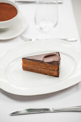 Portion of sweet chocolate cake dessert on white plate 