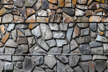 Fototapeta premium Irregular grey and brown stone wall texture with varied shapes and patterns