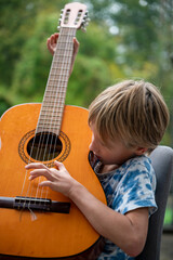 Curious child playing classical guitar