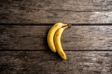 Two ripe bananas on rustic wooden background