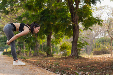 Beautiful Asian woman warming up her body to prepare her muscles for run to reduce muscle injuries during run exercise. Beautiful Asian woman stretching her muscles to prepare for run .