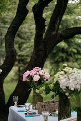 table with vases of flowers and supplies for making bouquets