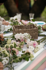 table with flowers and supplies for making bouquets
