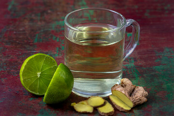 Warm ginger tea with lime on a rustic table