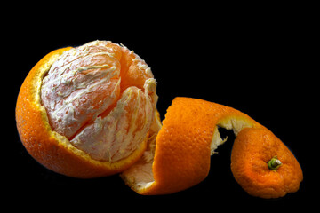 Fresh orange being peeled with a twist of zest