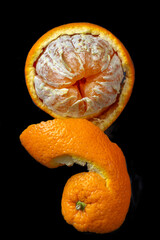 Orange peel and fruit on dark backdrop