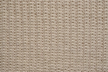 Fototapeta premium texture of knitted light brown sweater, close-up texture of beige knitted fabric, macro texture of tan knitted woolen clothes 