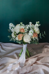 Bukiet weselny w jasnych kolorach na beżowej tkaninie © Anton