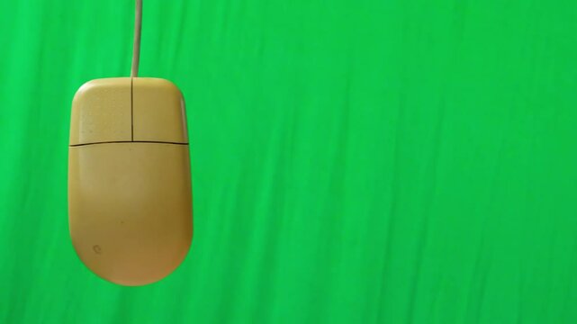 A close-up shot of a vintage beige computer mouse with a scroll wheel and two buttons, set against a neutral background. The design is characteristic of older computer peripherals