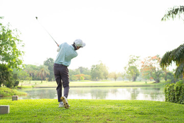 Asian amateur golfer is performing a tee off swing, man playing golf in golf course.