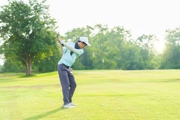 Asian amateur golfer is performing a tee off swing, man playing golf in golf course.