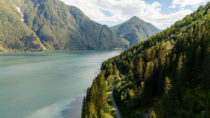 Nestled in Norway, stunning mountains rise dramatically over calm waters, framed by lush greenery. Perfect for outdoor enthusiasts,Fjaerland in Norway