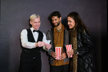 Couple showing their tickets to a cinema employee before watching a movie
