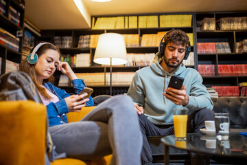 Disconnected Students Using Phones in Library Café